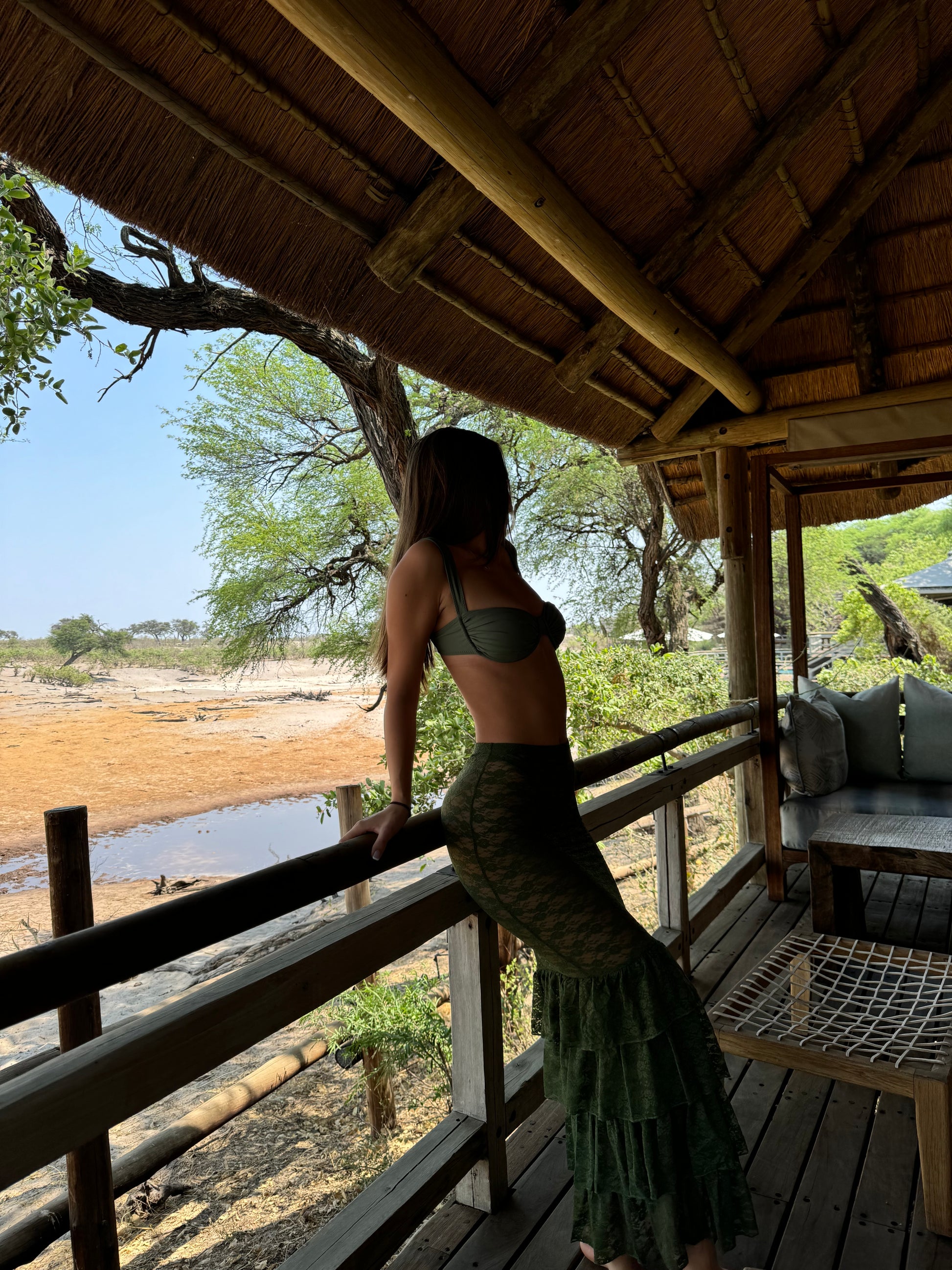 The Ruffle Moss Skirt, a fun and flirty cover-up that exudes effortless elegance. Crafted from dark green lace, this high-waisted skirt offers vintage vibes with a modern twist. Featuring a playful 4-tiered ruffle hem, it adds a touch of retro charm while ensuring maximum comfort. The neutral moss green color makes it versatile for any occasion, allowing you to stand out with timeless style. Perfect for beach days or casual outings, this skirt is a must-have addition to your wardrobe!