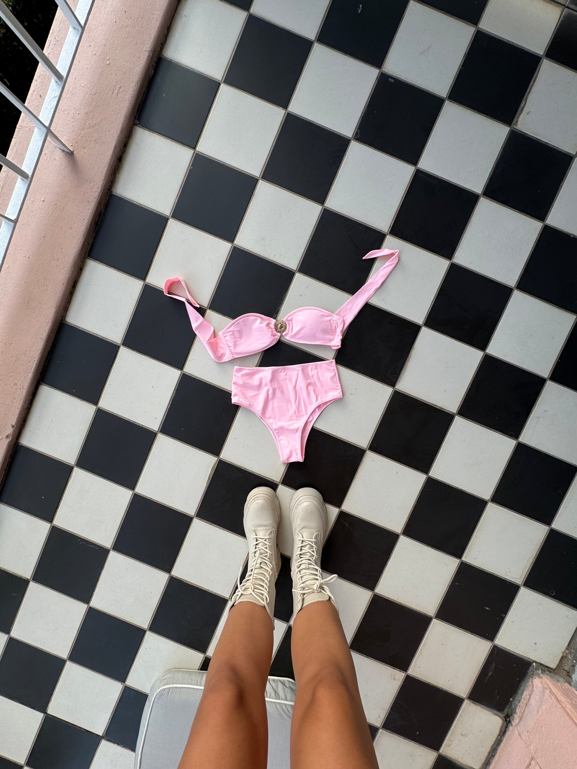 The Polly Pocket Bikini, inspired by vintage swimwear with a delightful retro-chic flair. This charming baby pink bikini features a bandeau-style top adorned with stunning gold hardware, adding a touch of elegance to your look. The high-waisted bottoms provide full coverage while flattering your silhouette, ensuring you feel confident and stylish. Perfect for channeling nostalgic vibes, The Polly Pocket Bikini is an essential addition to your summer wardrobe for fun days by the pool or beach!