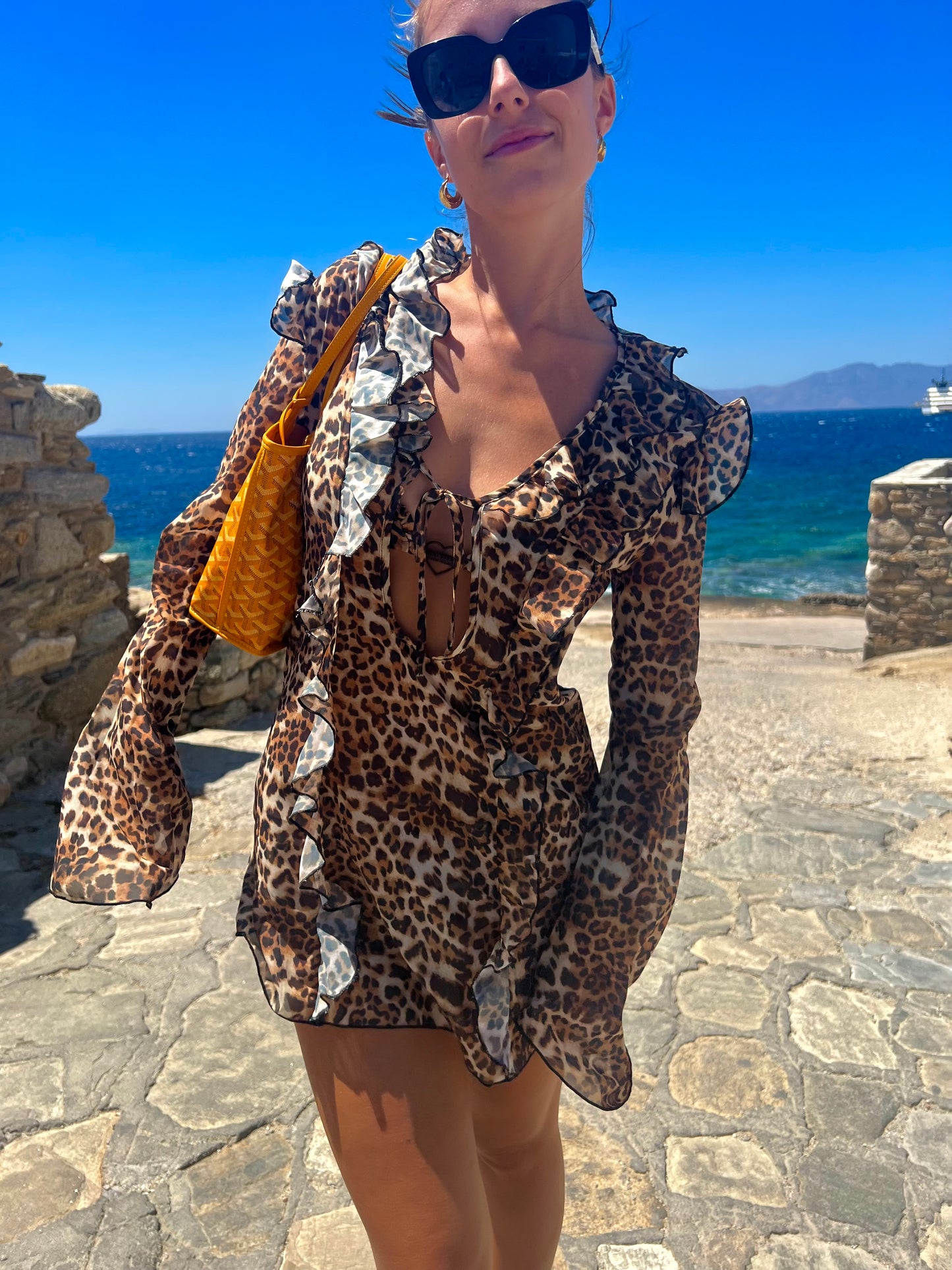 Make a bold statement with the Kit Kat Chiffon Dress, featuring a playful leopard print that exudes fierce femininity. The ruffled neckline adds a flirty touch, while the lightweight fabric ensures versatility as a stylish cover-up or a standout statement dress. Perfect for beach outings or casual gatherings, this dress combines wild charm with effortless elegance. Embrace your playful side and let the Kit Kat Chiffon Dress elevate your wardrobe with its vibrant personality and chic design!