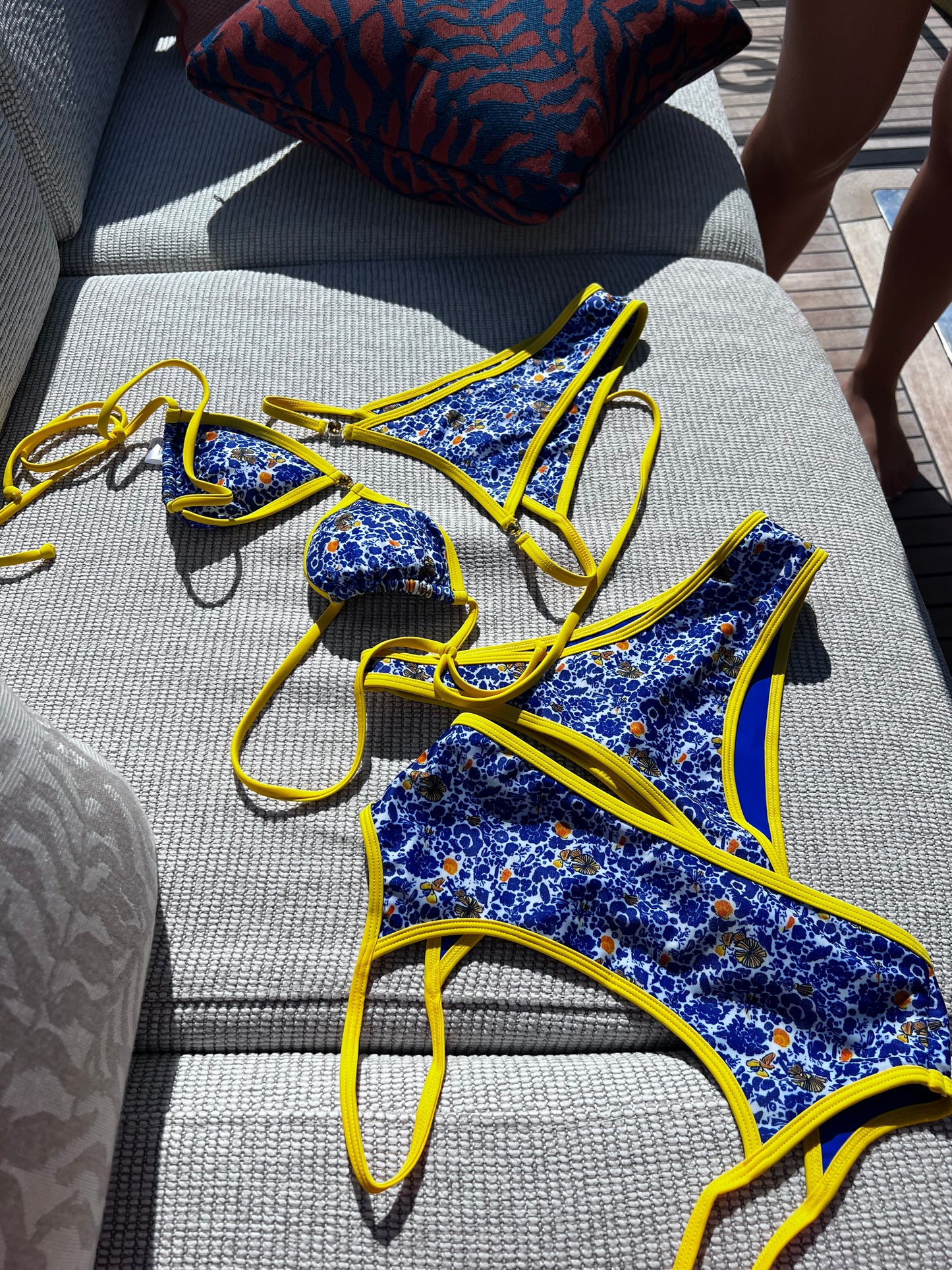 The Ophelia Bikini, a stunning statement piece that radiates vibrant energy. Featuring a classic blend of Mediterranean blue, vibrant yellow, and crisp white, this bikini is adorned with a bold floral print that evokes the beauty of Greece. The eye-catching yellow gemstone accents and matching straps add a touch of elegance. With its flattering fit and stylish design, this bikini is perfect for making a splash at the beach or pool this summer!