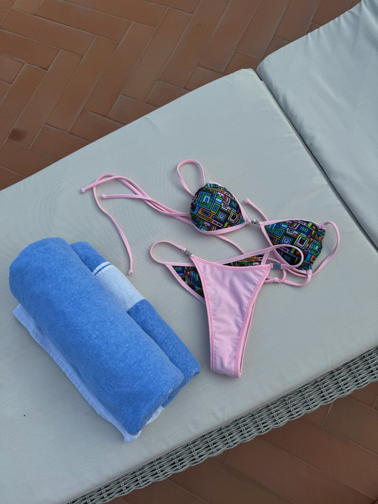 The Powder Puff Bikini, a vibrant swimwear piece that brings a fresh twist to your beach collection. Featuring an eye-catching abstract geometric design in a lively palette of green, blue, red, orange, yellow, and pink, this bikini is sure to turn heads. The playful pink trim and jewel details add a subtly dazzling touch. With its versatile fit and stylish design, the Powder Puff Bikini is perfect for making a bold statement while enjoying the sun and surf!
