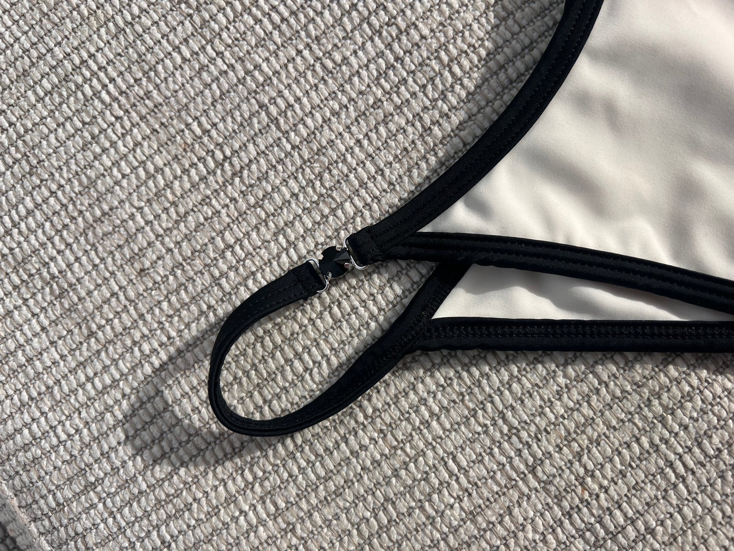 The Milos Bikini is a stunning blend of classic elegance and modern flair, featuring a monochrome palette of black and cream. This luxurious piece boasts sleek lines and exquisite black gem detailing, adding a touch of sophistication. Its design ensures a flattering fit that enhances your silhouette, making it perfect for any beach or poolside occasion. Elevate your swimwear collection with this timeless bikini that exudes confidence and style, effortlessly combining comfort with high-fashion appeal.