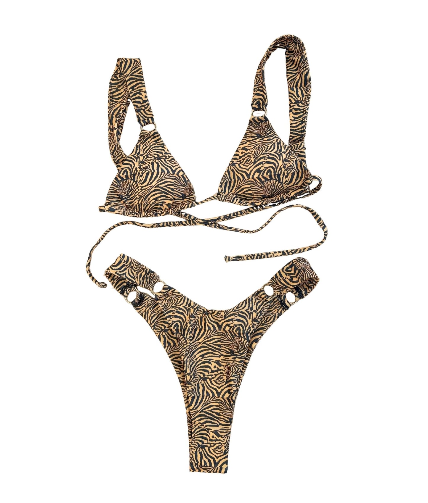 The Desert Lily Bikini, a striking swimwear choice that features bold tiger stripes for a truly wild style. Enhanced with glamorous gold ring details, this bikini exudes a fierce and sleek vibe that is sure to turn heads. Designed for both comfort and elegance, it offers a flattering fit that complements your figure. Perfect for beach days or pool parties, The Desert Lily Bikini is your go-to for making a bold statement while enjoying the sun!