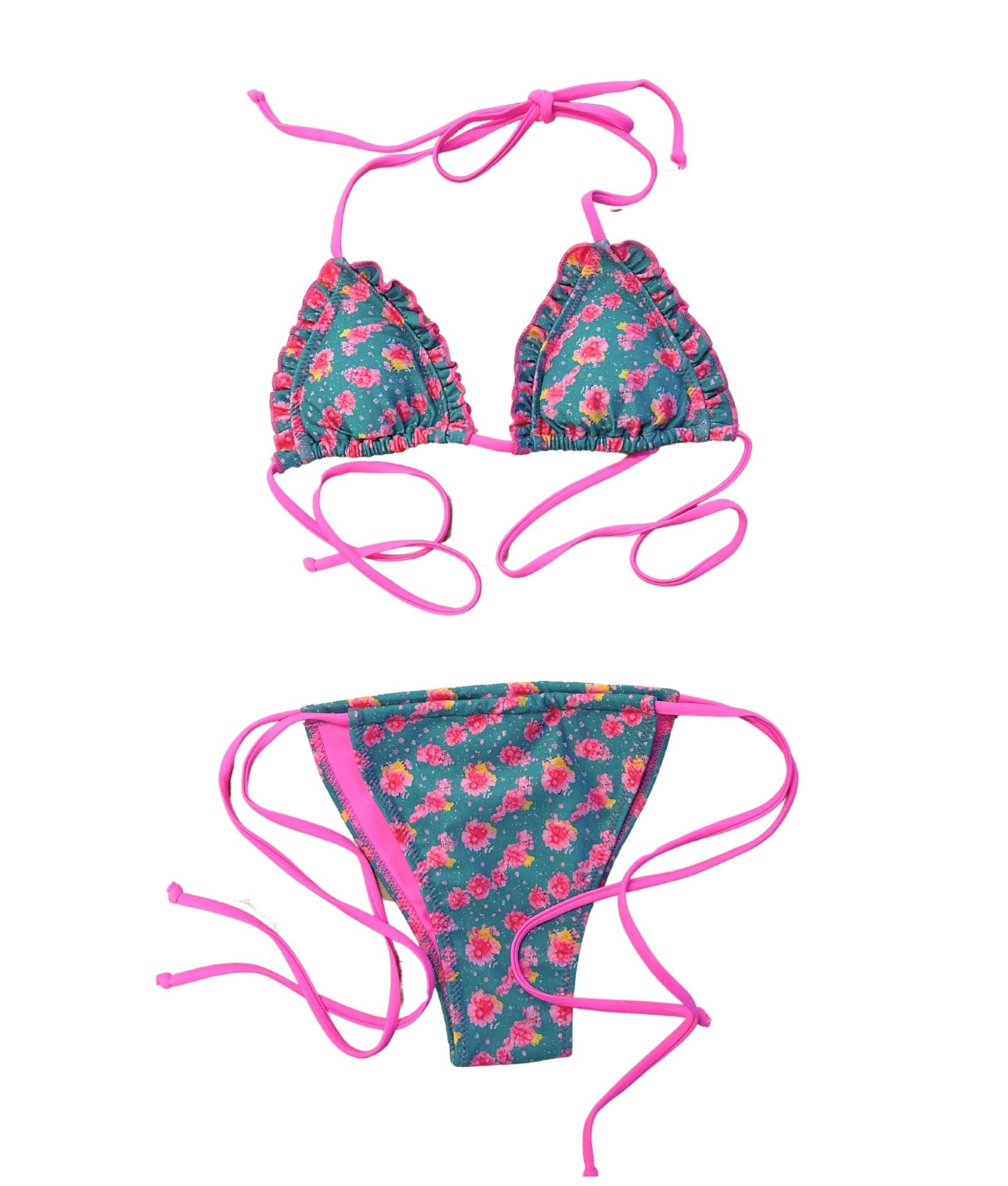 The Syros Bikini, a sweet and flirty swimwear choice that captures the essence of summer. Featuring a vibrant teal base adorned with hot pink florals, this bikini is designed to make your skin glow. The playful ruffle detail adds a charming touch, enhancing its feminine appeal. Crafted for comfort and confidence, it’s perfect for beach days or poolside lounging. Embrace your playful side and shine bright in The Syros Bikini, your go-to for sunny adventures!