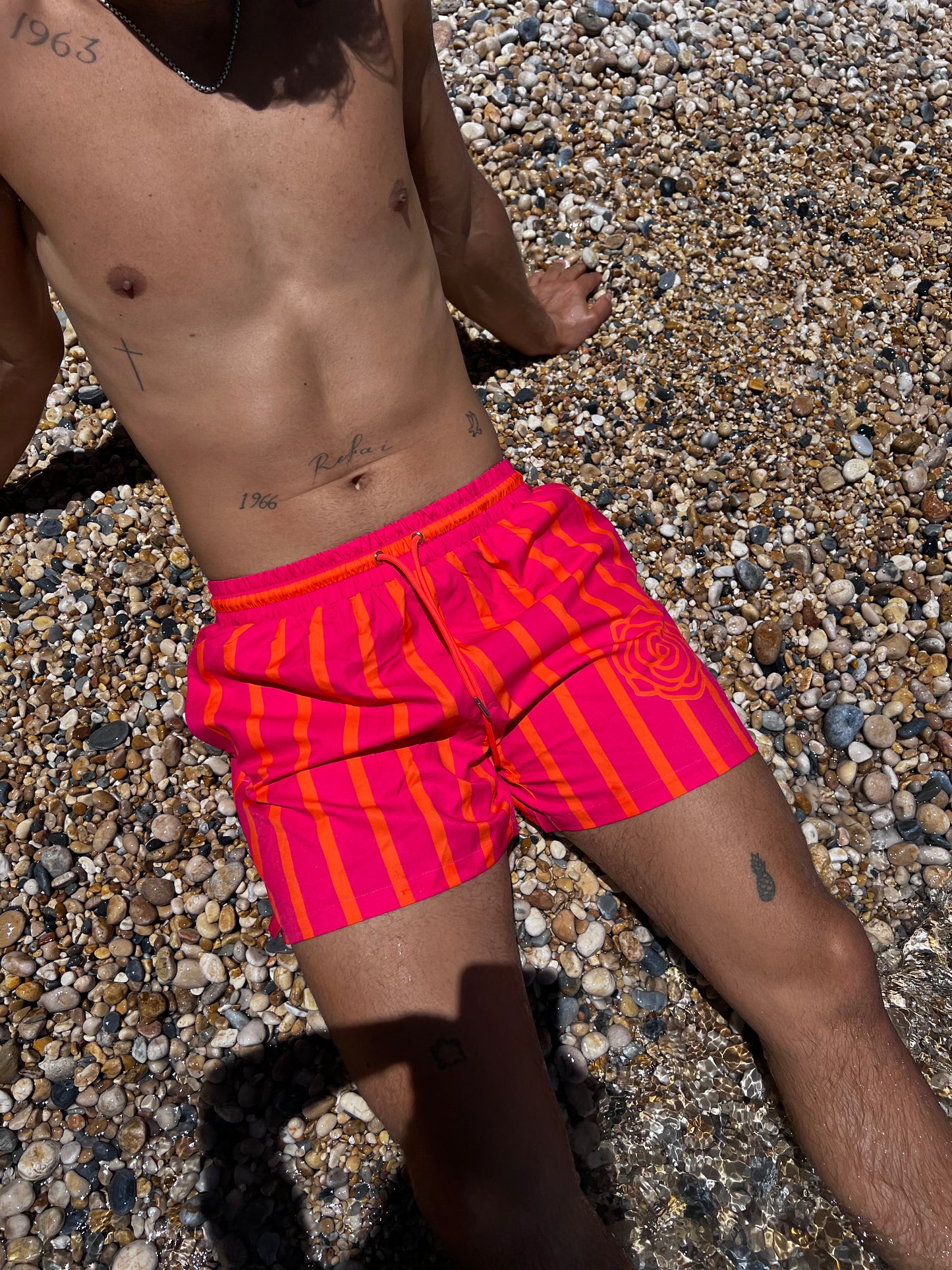 The Clair de Lune Short, a bold and vibrant choice for men. Featuring a striking pink base with eye-catching orange stripes, these shorts are designed to make a statement. Crafted from thicker, durable material, they ensure long-lasting wear while providing comfort. The tie-string waist allows for a customizable fit, and with three pockets featuring hidden zippers, you can keep your essentials secure. Perfect for beach days or casual outings, the Clair de Lune Short combines style and practicality!