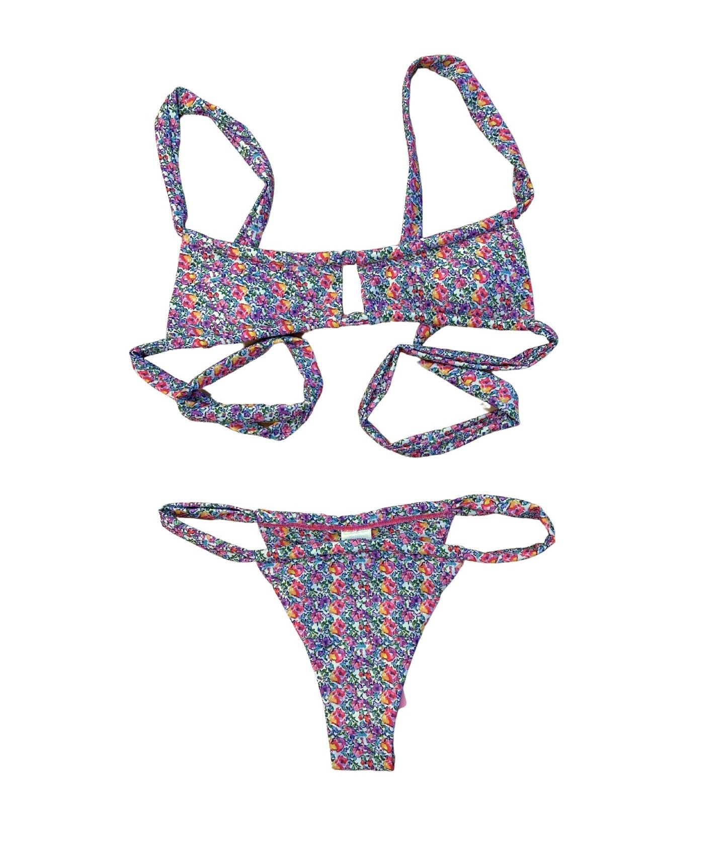 Embrace summer vibes with the Honeysuckle Bikini, adorned in dreamy pink and purple florals. The chic center cutout adds a trendy twist, while adjustable straps ensure personalized comfort for every body type. This sweet design perfectly balances style and support, making it ideal for beach days or pool parties. Stand out in this beautiful bikini and enjoy a flattering fit that celebrates your unique style!