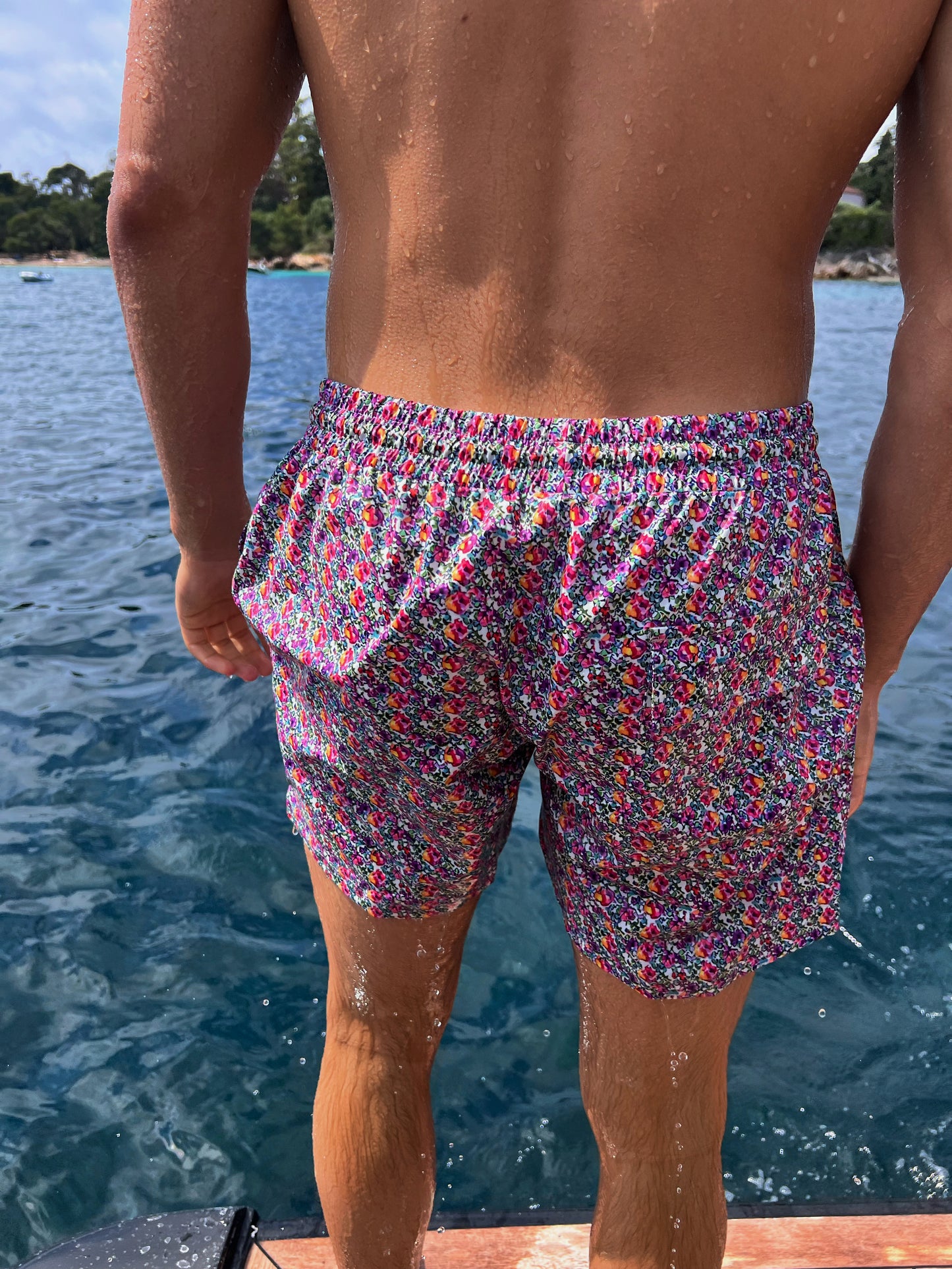 The Saint Tropez Short, the ultimate men's swim shorts that blend functionality and fashion. Featuring a vibrant floral print in purple and pink, these shorts embody effortless tropical vibes. Designed for comfort, they include a convenient string tie for a secure fit and functional pockets for your essentials. Versatile enough for beach days or pool parties, The Saint Tropez Short is a stylish choice that ensures you stand out while enjoying the sun!