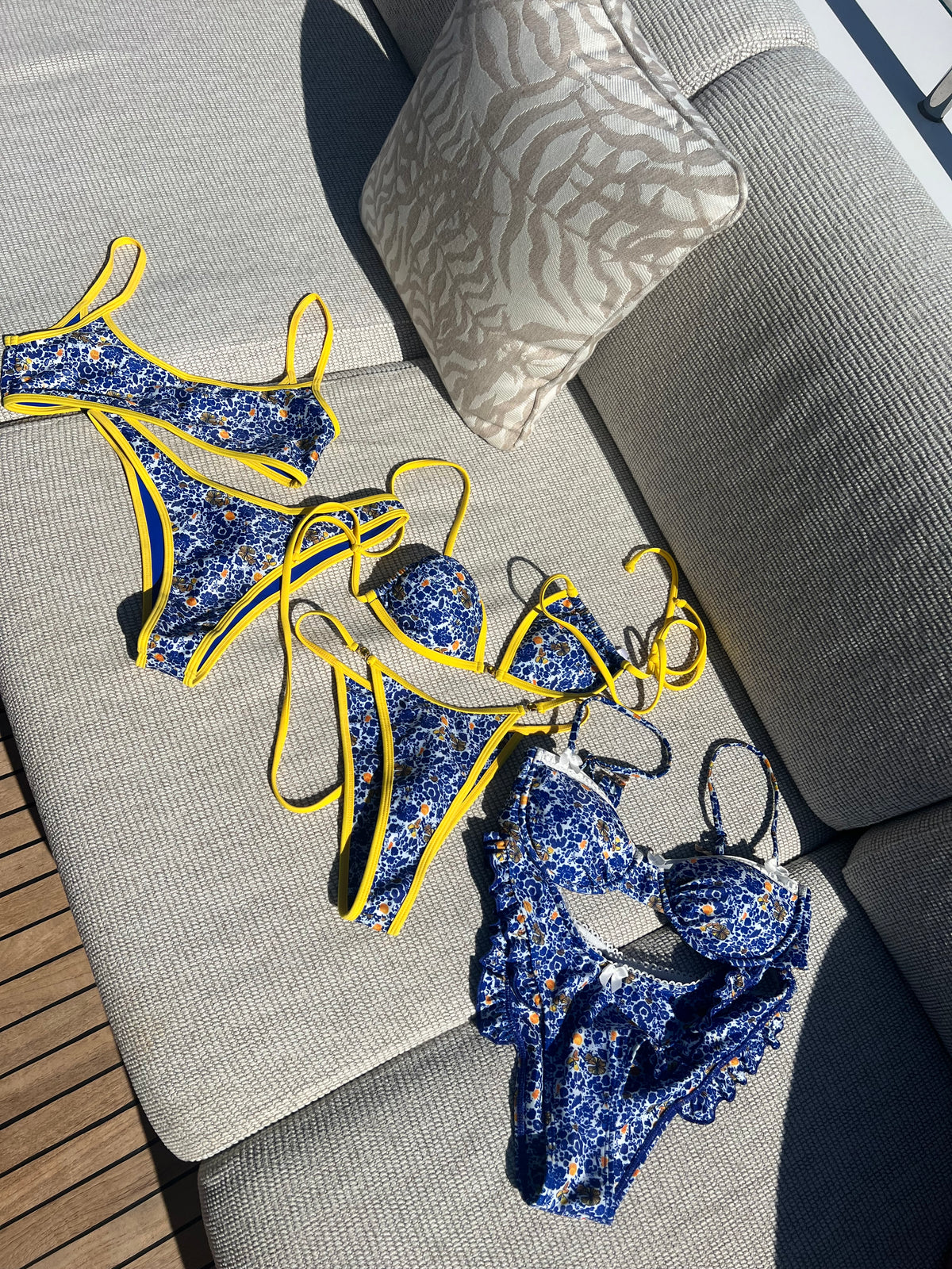 The Ophelia Bikini, a stunning statement piece that radiates vibrant energy. Featuring a classic blend of Mediterranean blue, vibrant yellow, and crisp white, this bikini is adorned with a bold floral print that evokes the beauty of Greece. The eye-catching yellow gemstone accents and matching straps add a touch of elegance. With its flattering fit and stylish design, this bikini is perfect for making a splash at the beach or pool this summer!