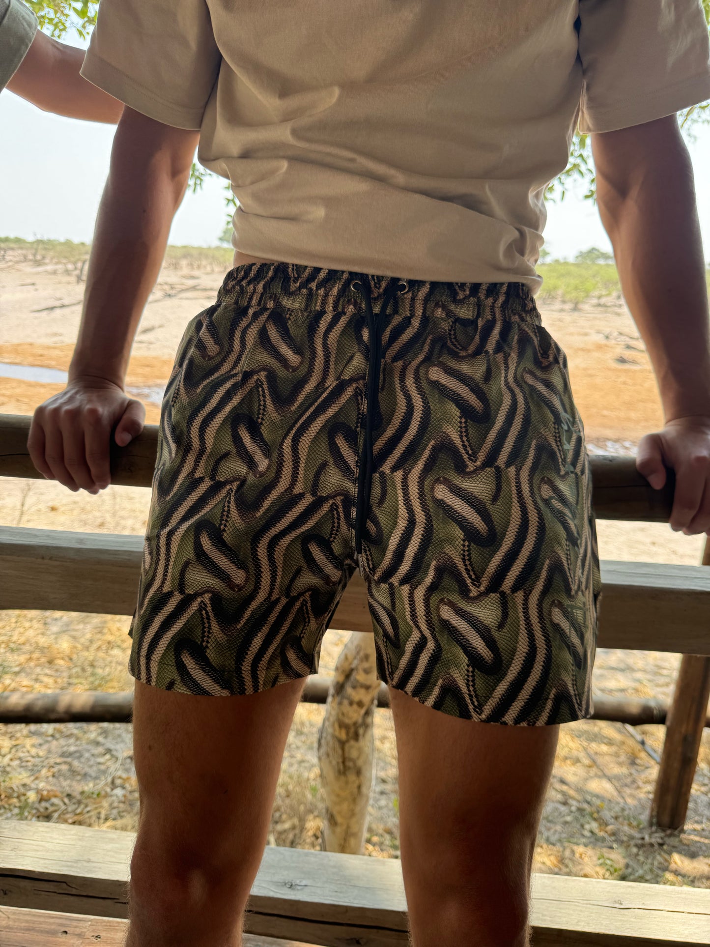 The Mamba Short, stylish men's swim trunks featuring a bold snake print design that stands out in any setting. Perfect for both swimming and streetwear, these shorts offer maximum freedom of movement and a sleek fit for all-day comfort. Crafted from high-quality materials, they are designed to keep you looking sharp whether you're at the beach or out on the town. Embrace your adventurous spirit with The Mamba Short, where style meets practicality for every summer adventure!