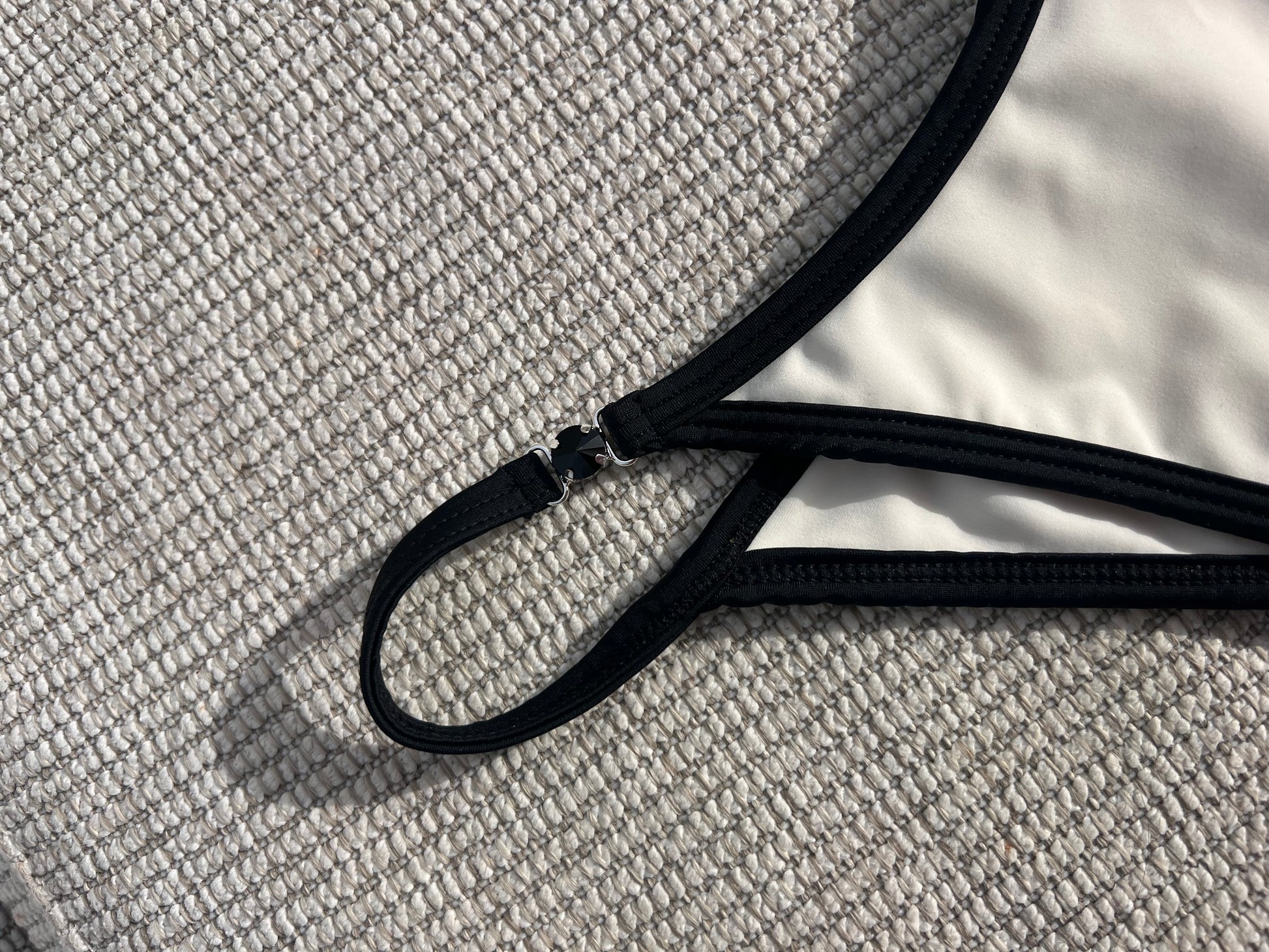 The Milos Bikini is a stunning blend of classic elegance and modern flair, featuring a monochrome palette of black and cream. This luxurious piece boasts sleek lines and exquisite black gem detailing, adding a touch of sophistication. Its design ensures a flattering fit that enhances your silhouette, making it perfect for any beach or poolside occasion. Elevate your swimwear collection with this timeless bikini that exudes confidence and style, effortlessly combining comfort with high-fashion appeal.