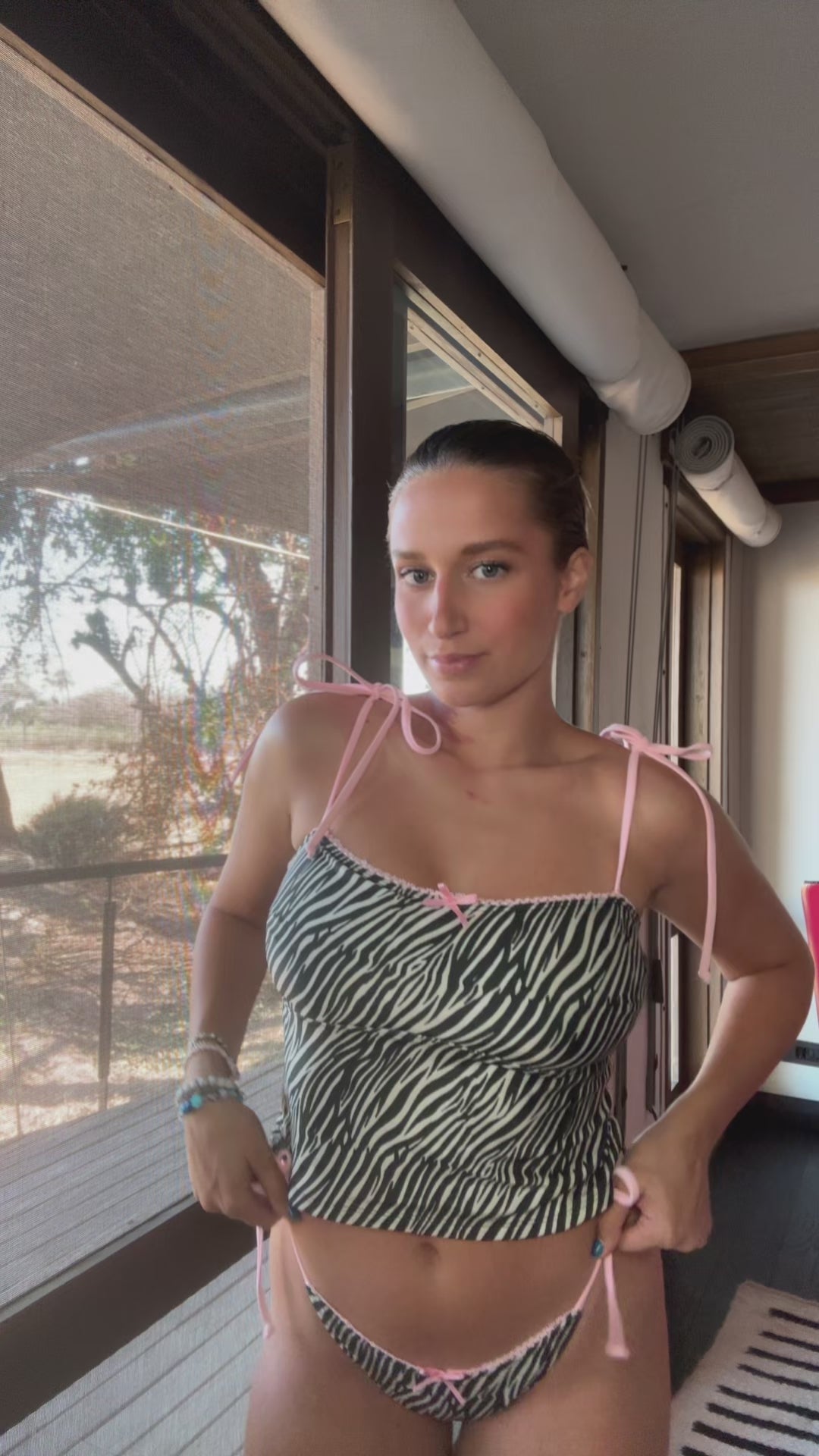 Zed, a stunning zebra print tankini, is the perfect blend of style and comfort! This eye-catching two-piece features adjustable baby pink spaghetti straps that provide a customizable fit, ensuring you feel confident and secure while enjoying the sun. The playful zebra print adds a bold statement to your beachwear collection, while the delicate lace trim offers a touch of femininity. A dainty front bow enhances the charm of this tankini, making it not just a swimsuit but a fashionable piece that stands out!
